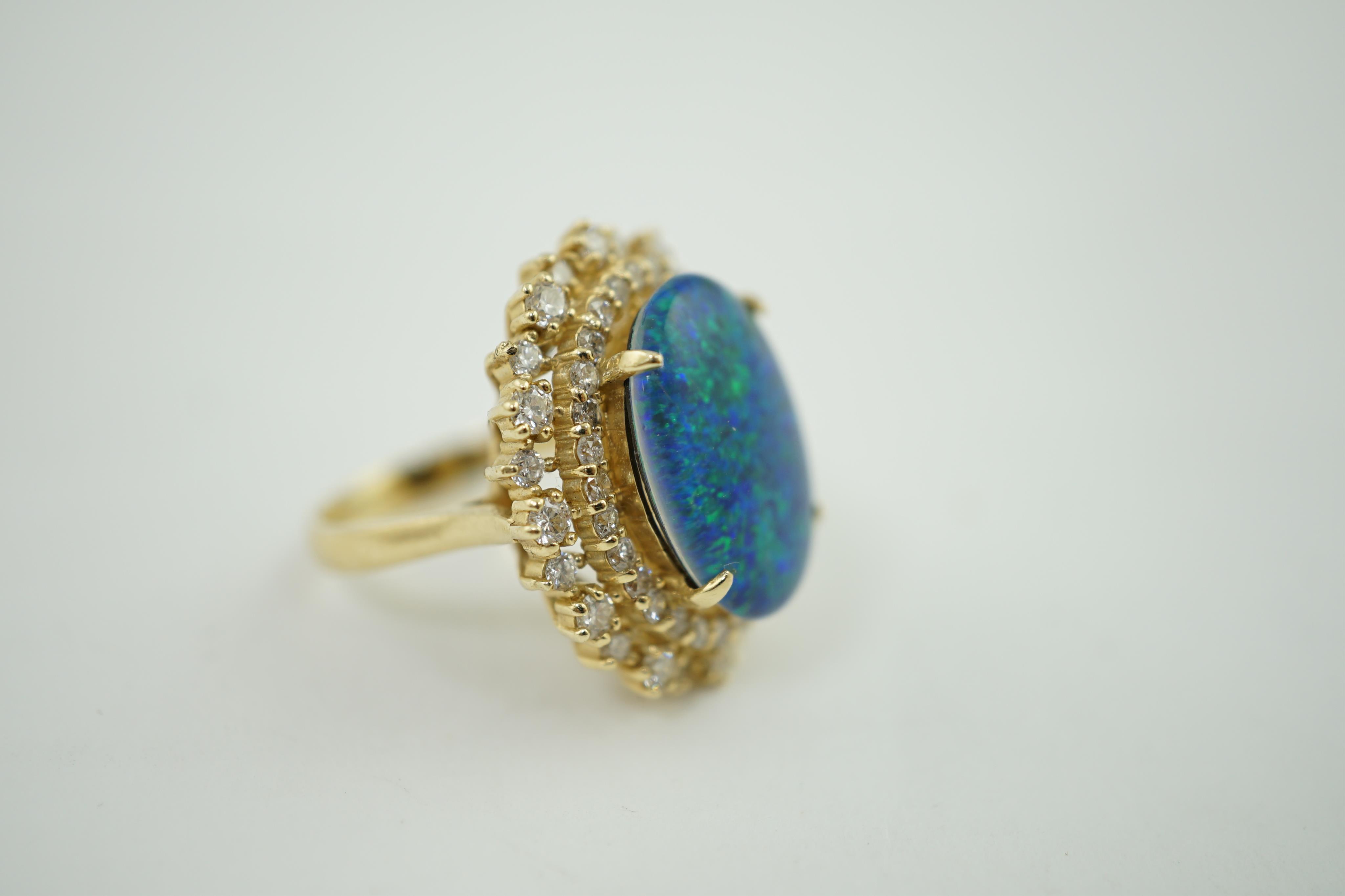 A modern American 14k gold, black opal doublet and diamond cluster set oval dress ring